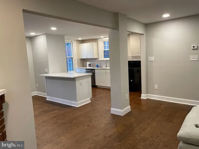 a large white kitchen with a stove a sink a refrigerator and a fireplace