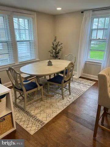 a dining room with furniture window and wooden floor