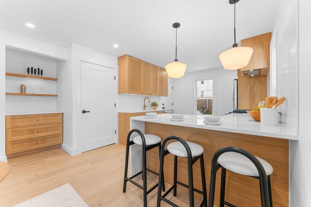 57 Weld Hill Street, Unit 2 Boston, MA 02130 - Photo 6 of 26 a kitchen with stainless steel appliances granite countertop a table and chairs in it