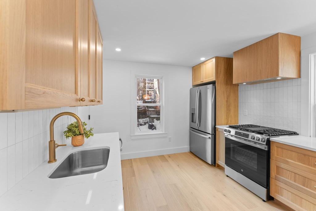 57 Weld Hill Street, Unit 2 Boston, MA 02130 - Photo 7 of 26 a kitchen with stainless steel appliances granite countertop a refrigerator sink and stove