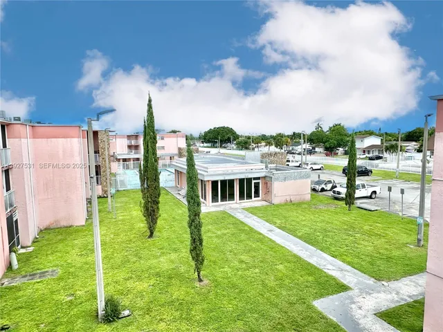 a view of a house with a big yard and a fountain