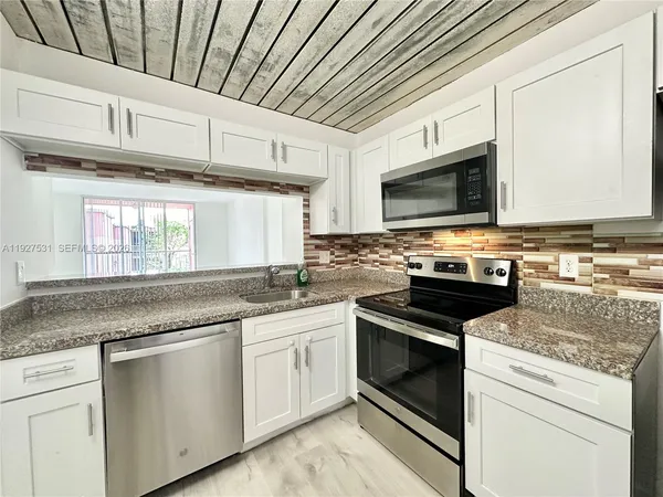 a kitchen with a refrigerator stove and microwave