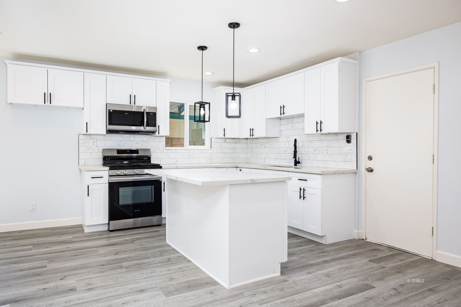 517 Vera Avenue Ridgecrest, CA 93555 - Photo 6 of 23 a kitchen with kitchen island white cabinets and stainless steel appliances