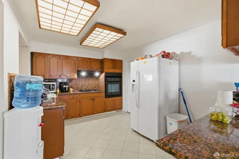 a kitchen with stainless steel appliances granite countertop a refrigerator and a stove top oven
