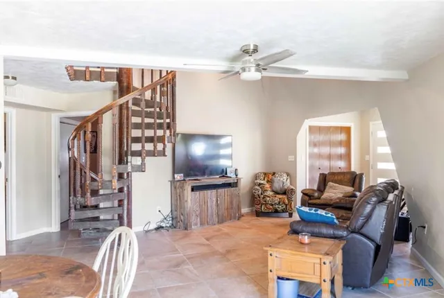 a living room with furniture a dining table and chairs with wooden floor