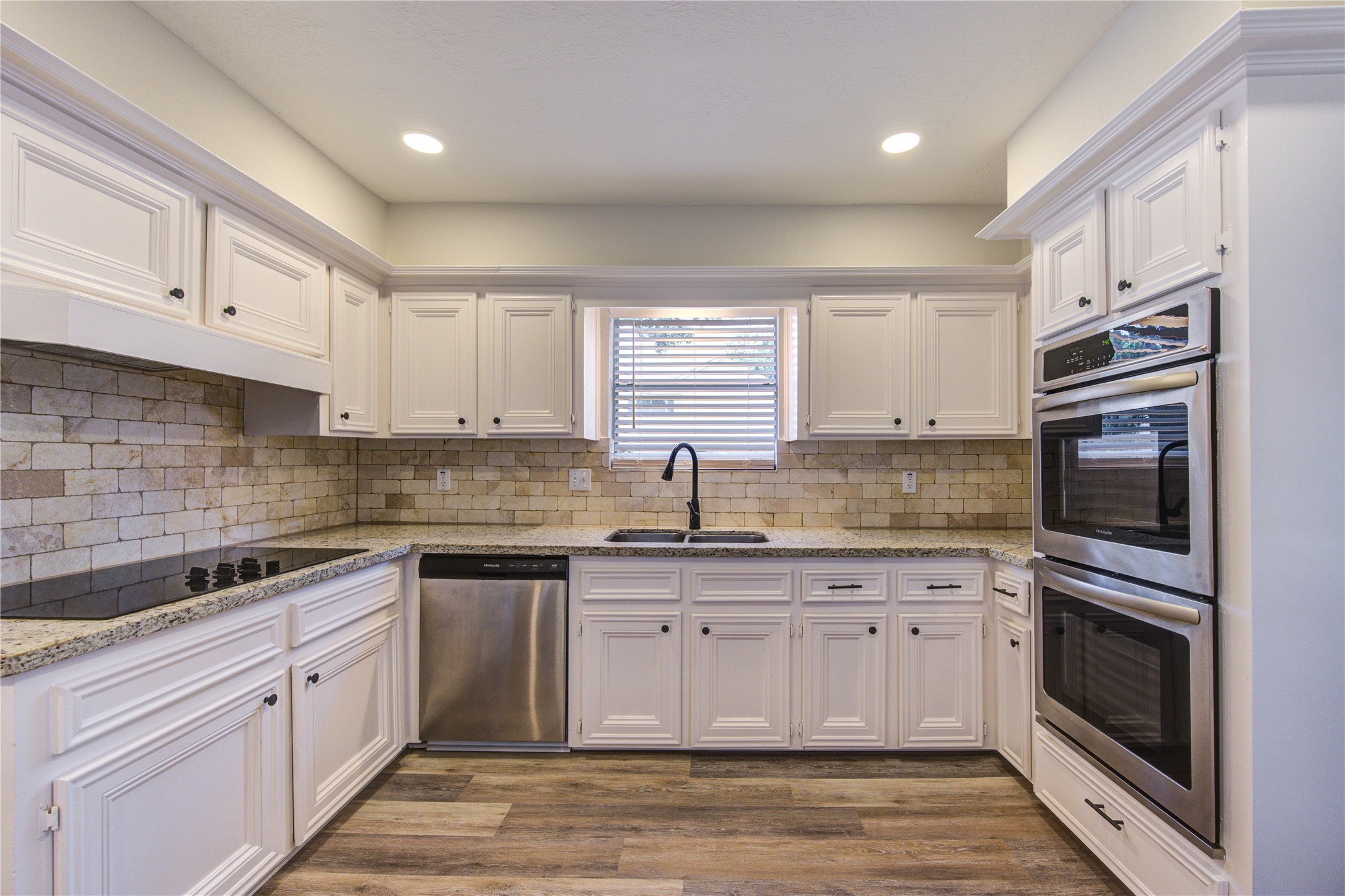 9115 Taidswood Drive Spring, TX 77379 - Photo 17 of 45 The kitchen has a travertine backsplash and beautiful granite counters.