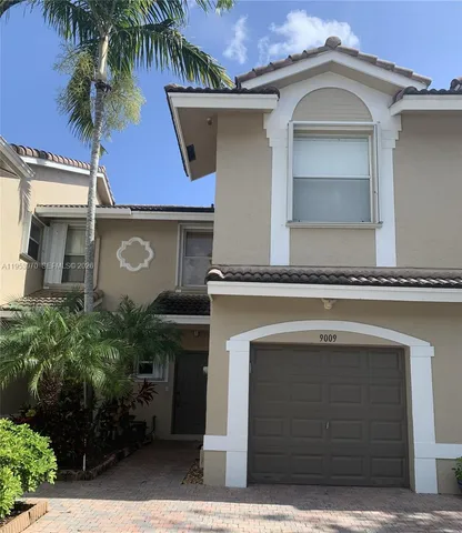 a front view of a house with plants