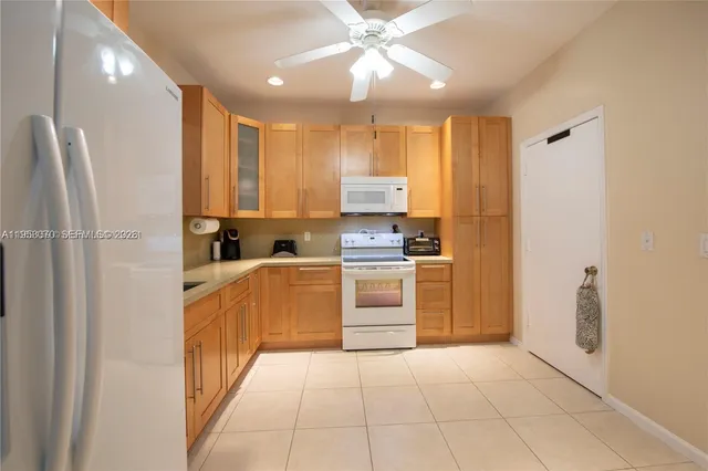 a kitchen with white cabinets and white appliances