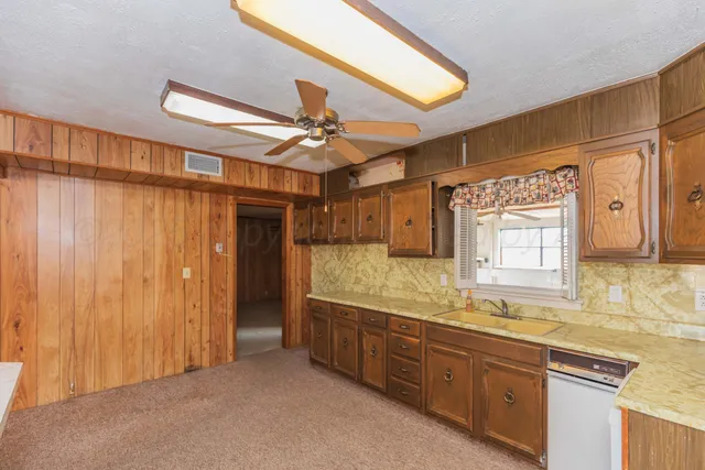 an empty room with a ceiling fan and a window