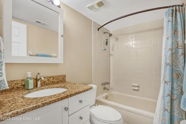 a bathroom with a granite countertop sink mirror toilet and bathtub
