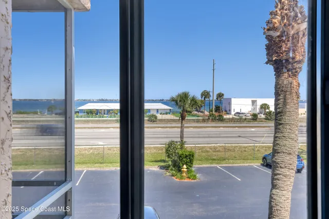 a view of a balcony with a floor to ceiling window next to a yard