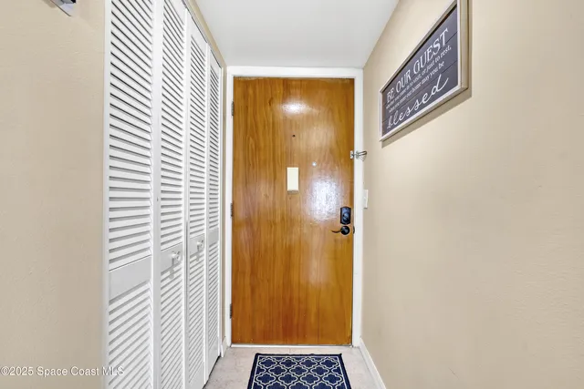 a view of a hallway with wooden floor and a bathroom