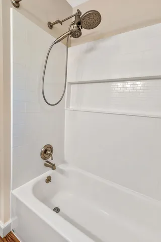 a bathroom with a bath tub with a shower