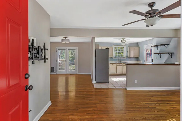 a view of a kitchen with kitchen island a sink wooden floor and appliances