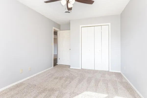 an empty room with a chandelier fan
