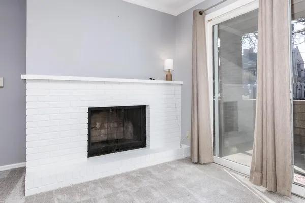 a living room with a fireplace and a glass door