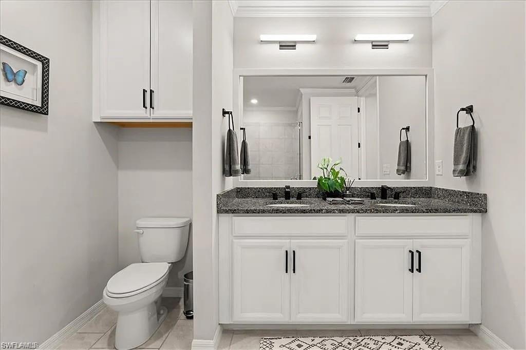 14672 Edgewater Circle Naples, FL 34114 - Photo 20 of 41 a bathroom with a granite countertop sink a toilet and a mirror