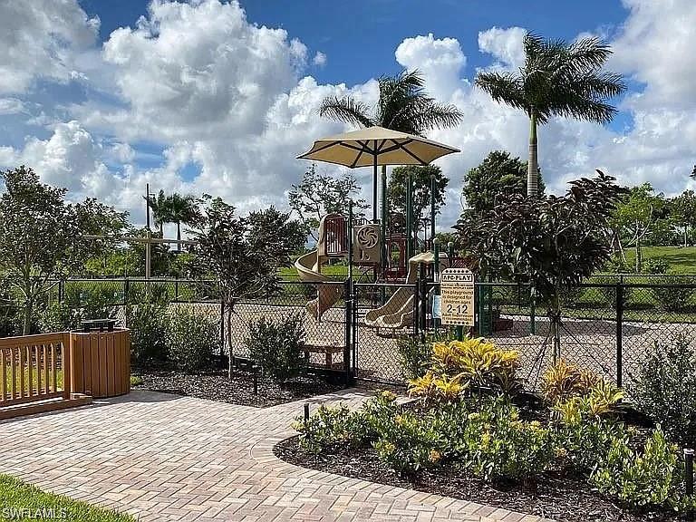 14672 Edgewater Circle Naples, FL 34114 - Photo 31 of 41 a view of a chair and tables with umbrella in the patio