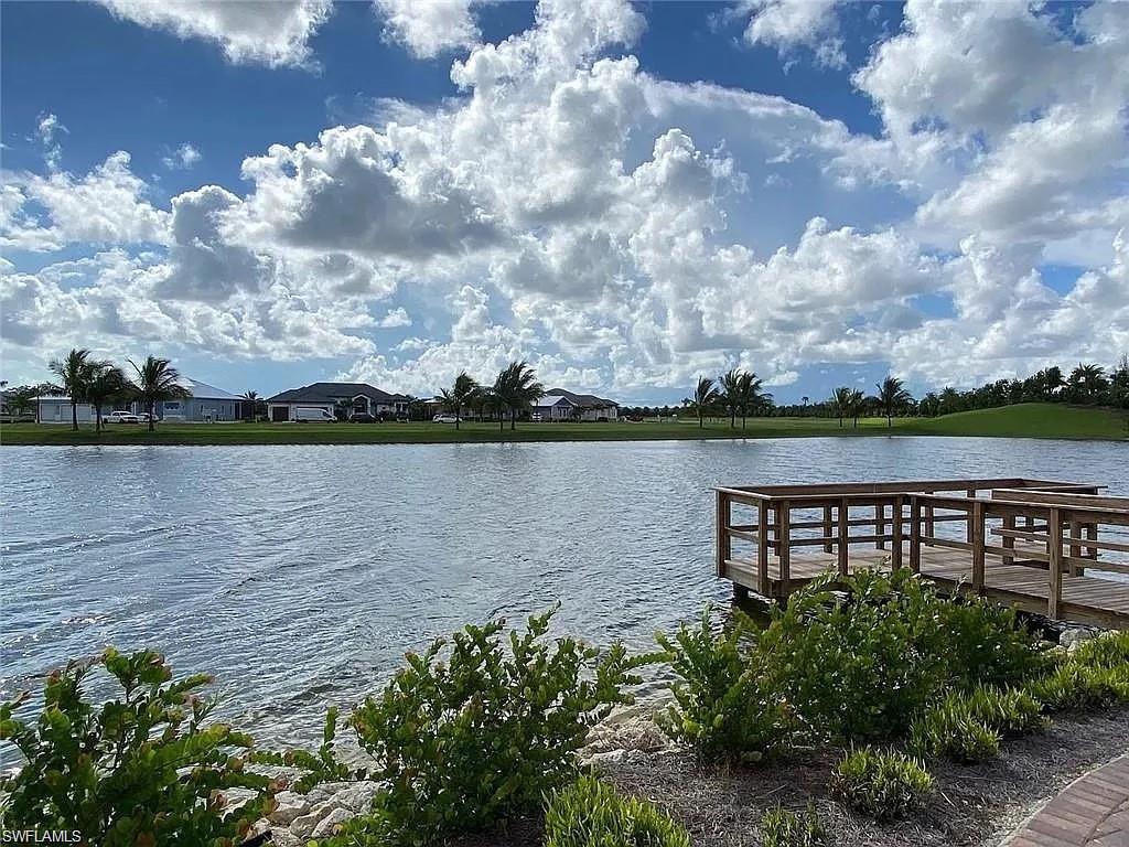 14672 Edgewater Circle Naples, FL 34114 - Photo 40 of 41 a view of a lake with a house in the background