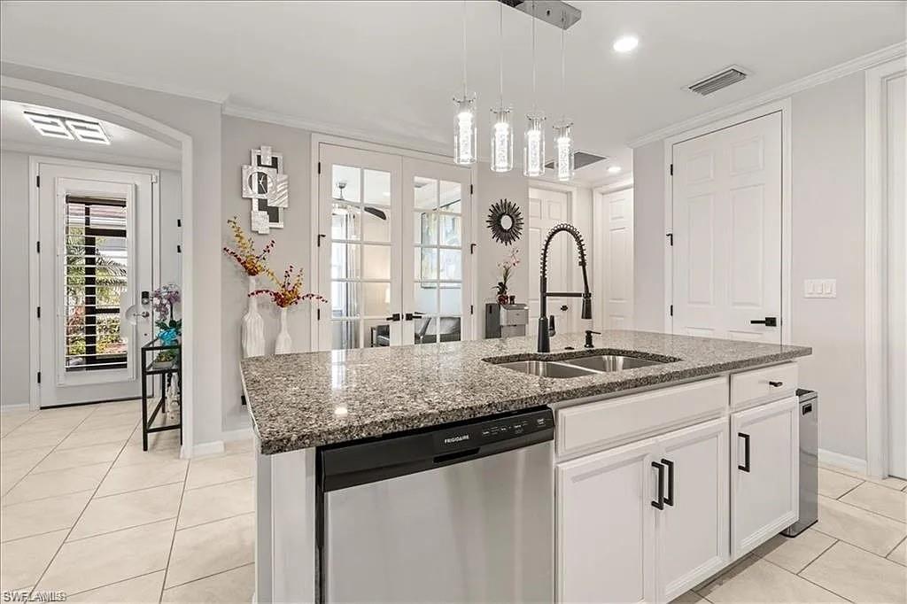 14672 Edgewater Circle Naples, FL 34114 - Photo 9 of 41 a kitchen with granite countertop a sink and white cabinets
