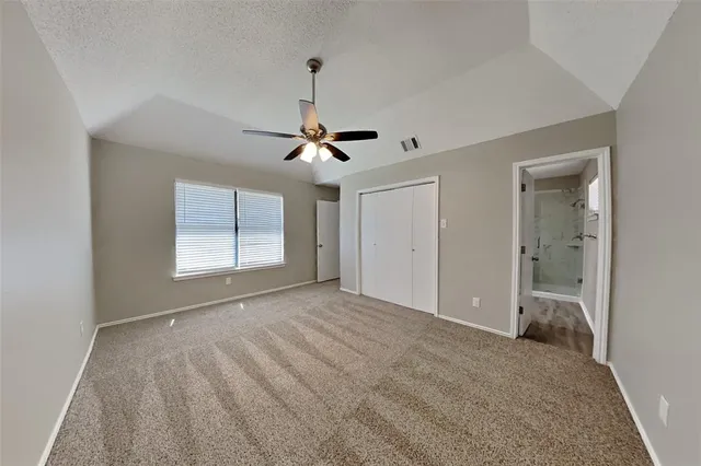 a view of an empty room with window and chandelier fan