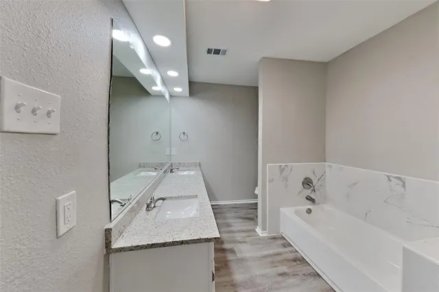 a bathroom with a granite countertop sink a toilet and bathtub