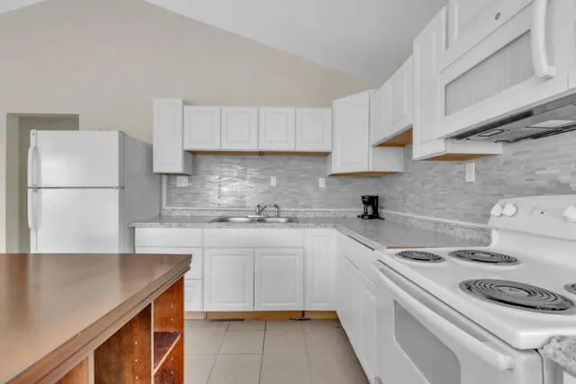 a kitchen with a white cabinets stove and refrigerator