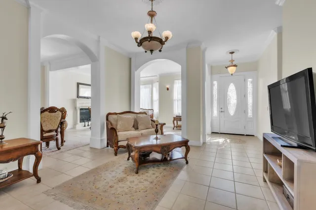a living room with furniture a fireplace and a chandelier
