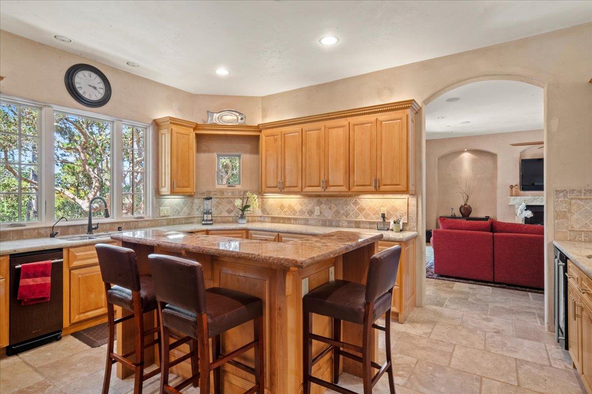 2970 Congress Road Pebble Beach, CA 93953 - Photo 16 of 37 a kitchen with stainless steel appliances granite countertop a table chairs sink and cabinets