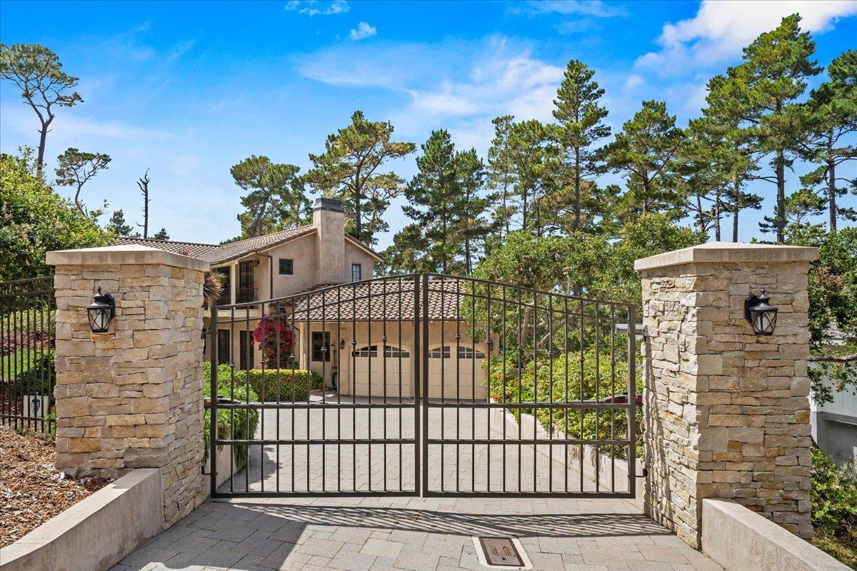 2970 Congress Road Pebble Beach, CA 93953 - Photo 2 of 37 a view of a brick house that has large tree and a yard