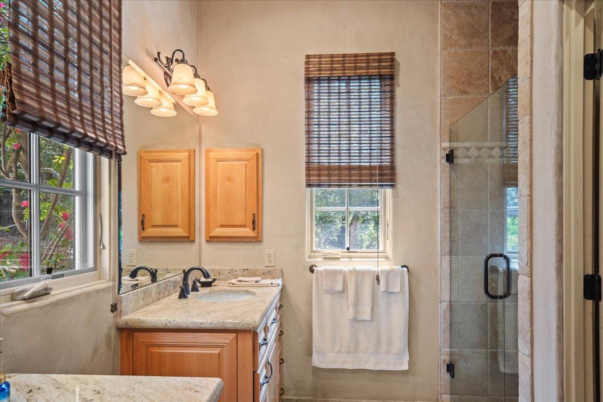 2970 Congress Road Pebble Beach, CA 93953 - Photo 21 of 37 a bathroom with a granite countertop sink a mirror and a shower