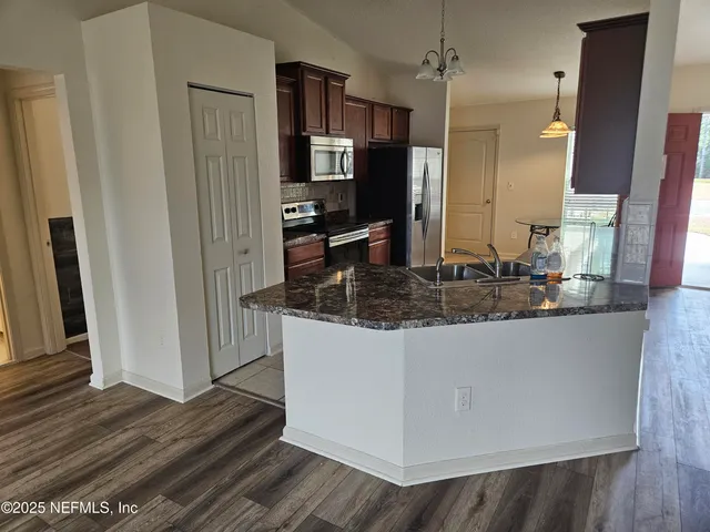 a kitchen with stainless steel appliances granite countertop a refrigerator and a sink