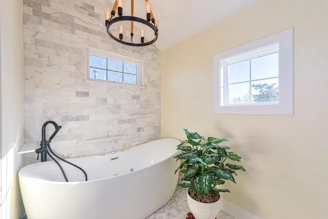 a bath tub sitting in a bathroom next to a window