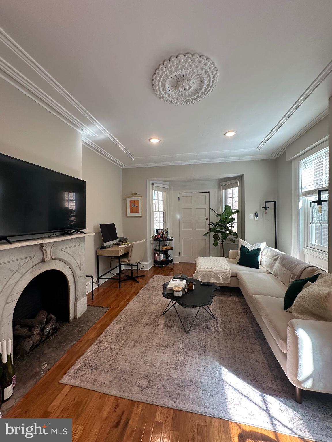 a living room with furniture a fireplace and a flat screen tv