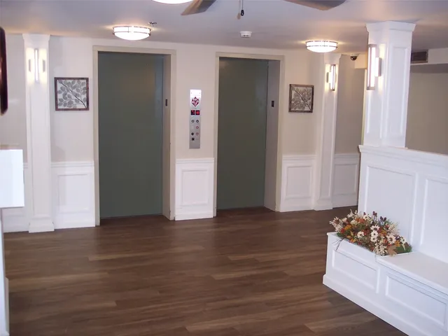 a living room with hard wood floors and a kitchen