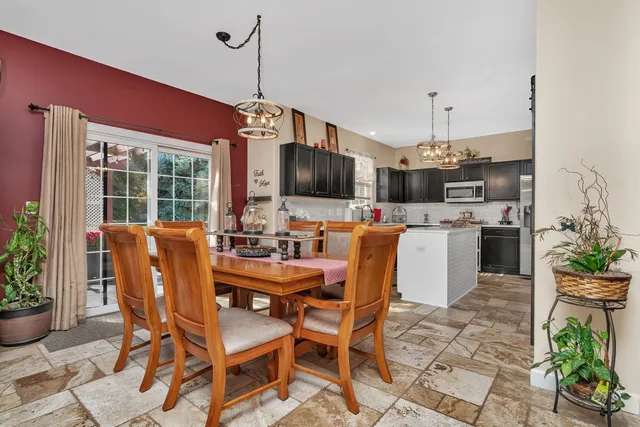 a dining room with furniture a chandelier and wooden floor