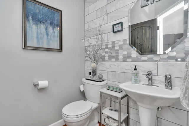 a bathroom with a toilet a sink and mirror