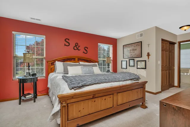 a bedroom with a bed and large windows