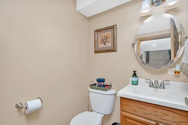 a white toilet sitting next to a bathroom sink and a mirror