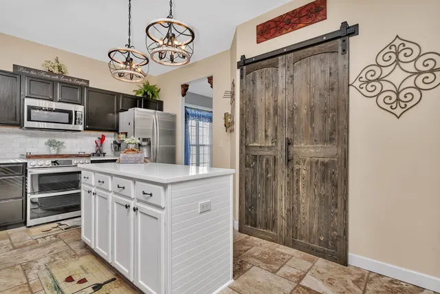 a kitchen with stainless steel appliances granite countertop a stove and a refrigerator