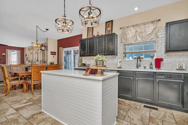 a kitchen with stainless steel appliances granite countertop a sink and a large window
