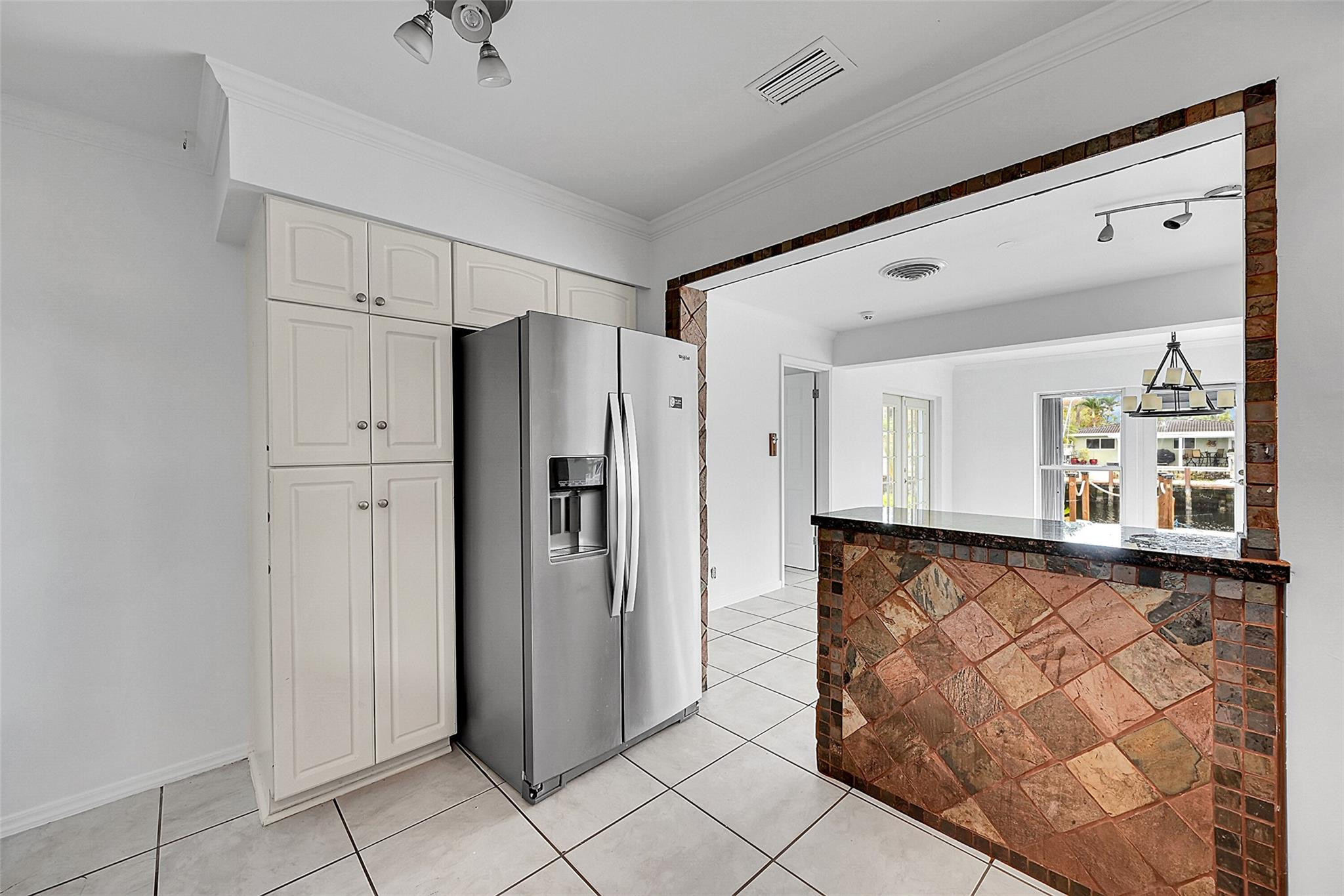 220 Southeast 10th Street Pompano Beach, FL 33060 - Photo 14 of 42 a view of a refrigerator in kitchen and an empty room in wooden floor