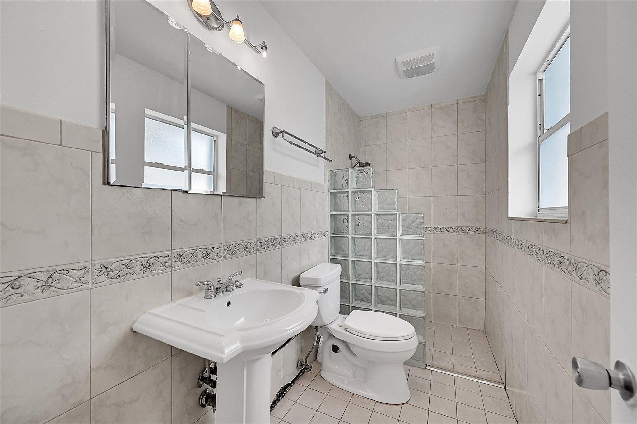 220 Southeast 10th Street Pompano Beach, FL 33060 - Photo 20 of 42 a bathroom with a sink mirror and toilet