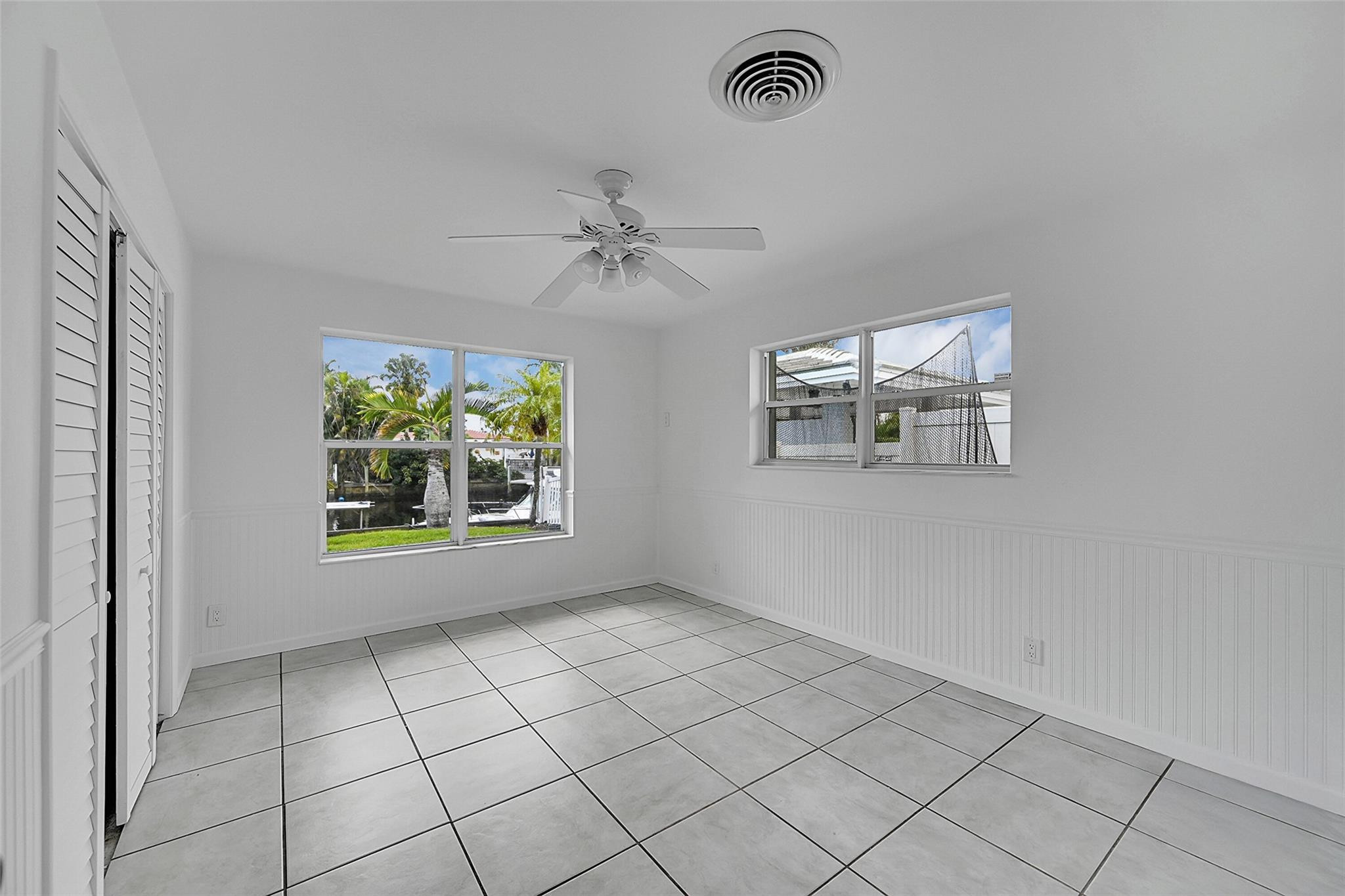 220 Southeast 10th Street Pompano Beach, FL 33060 - Photo 21 of 42 an empty room with windows and ceiling fan