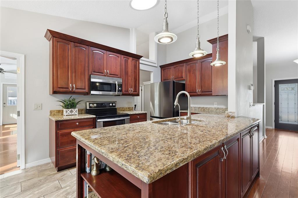 3488 Ridge Boulevard Palm Harbor, FL 34684 - Photo 8 of 30 a kitchen with granite countertop kitchen island a sink stove and refrigerator