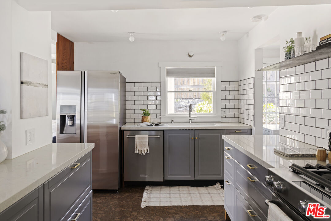 10536 Pinewood Avenue Tujunga, CA 91042 - Photo 13 of 33 a kitchen with stainless steel appliances granite countertop a sink stove and refrigerator