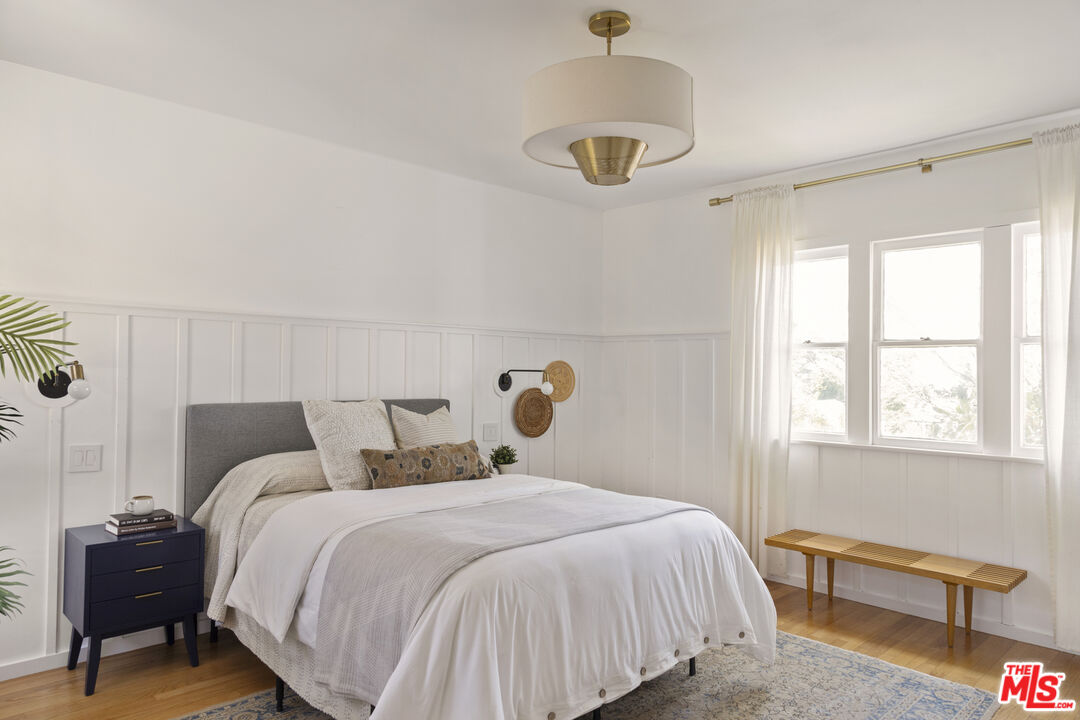 10536 Pinewood Avenue Tujunga, CA 91042 - Photo 17 of 33 a bedroom with a bed and a chandelier