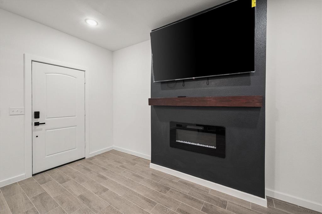 6771 Northwest County Road 1146 Barry, TX 75102 - Photo 3 of 34 a living room with a fireplace and a flat screen tv