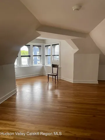 a view of empty room with wooden floor and floor to ceiling window