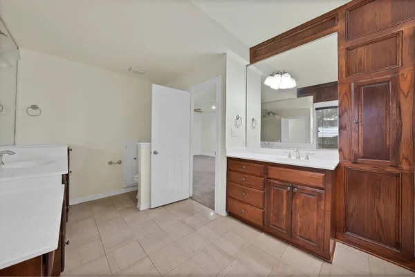a spacious bathroom with a granite countertop sink and a mirror